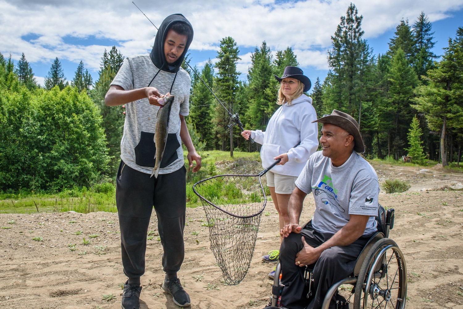 Mike Stiles fishes from a dock during the Fishing Forever event organizes by Osoyoos Wildlife Federation for people with disabilities. The private pond stocked with rainbow trout is wheelchair accessible. (Richard McGuire photo)