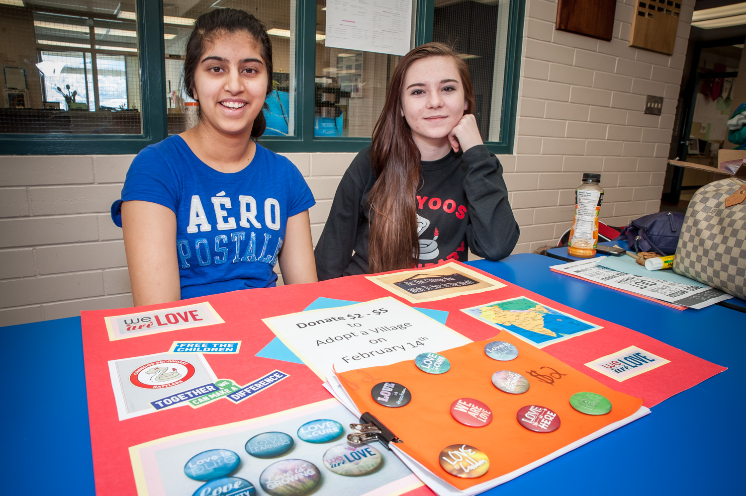 Kuljeet Wander (left), a Grade 12 student at Osoyoos Secondary School, has started a project to raise funds for a village in India by selling buttons proclaiming love. She is helped by other students of the school's Global Awareness Club and Student Parliament, such as Josie McCullough in Grade 9. (Richard McGuire photo)