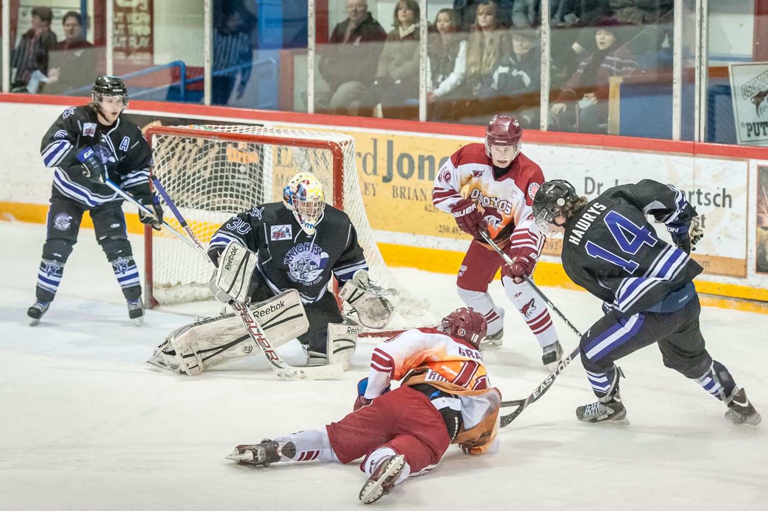 Luc Gradisar (on the ice) and Rainer Glimpel, both of the Coyotes, scramble for the puck in the North Okanagan end in Saturday's game at the Sun Bowl against the Knights. Osoyoos came back from behind to win 4-3 in overtime. (Richard McGuire photo)