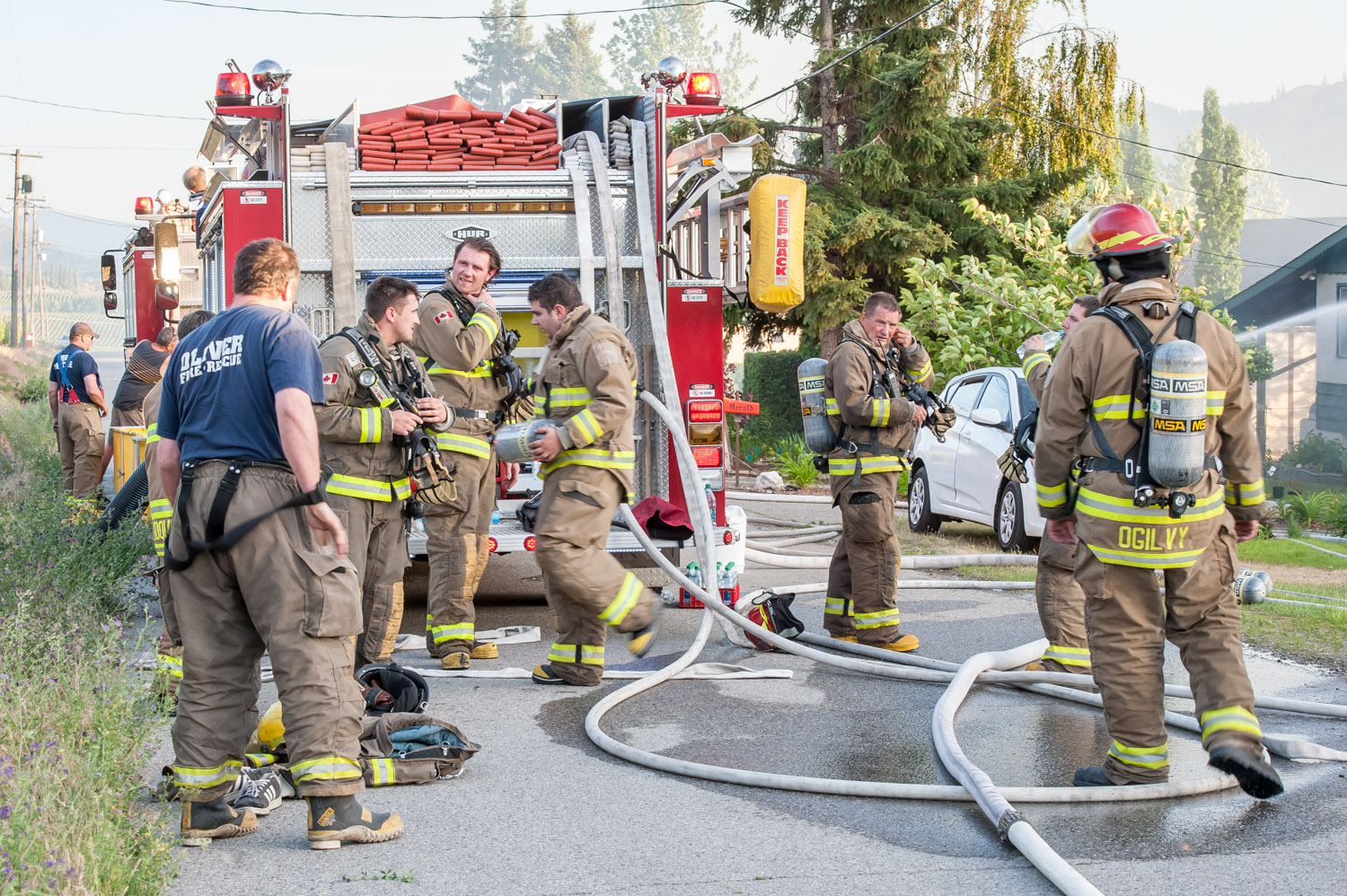 While their colleagues continue battling the blaze, some firefighters took a much-needed break. This was their third call of the day. (Richard McGuire photo)