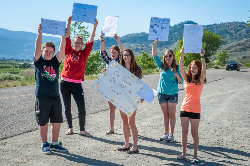 A small group of about a dozen students protested Wednesday in front of Osoyoos Secondary School against the labour dispute affecting teachers. Students were critical of both the teachers and the government and said the dispute is affecting their ability to seek help from teachers over the lunch break. Some more students walked out, but simply went home. Principal Mike Safek asked the students not to walk out and told them there are other ways to make their views known. (Richard McGuire photo)