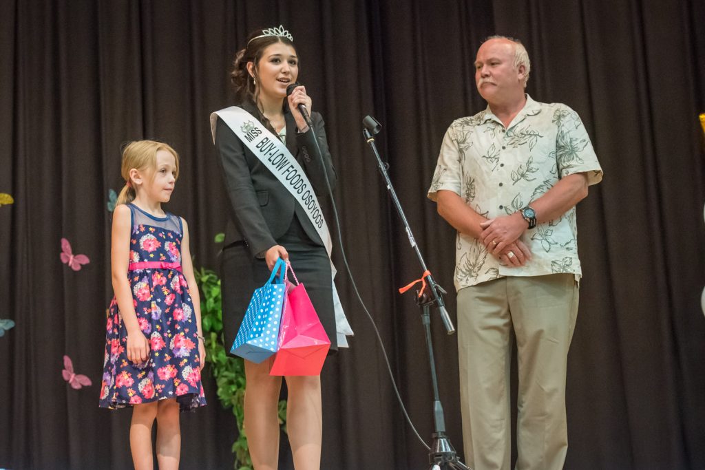 Contestant Tianna Morgan (centre) arrives on stage with her little buddy Jordan Kazakoff and her sponsor Brian Fry, of Buy-Low Foods. (Richard McGuire photo)