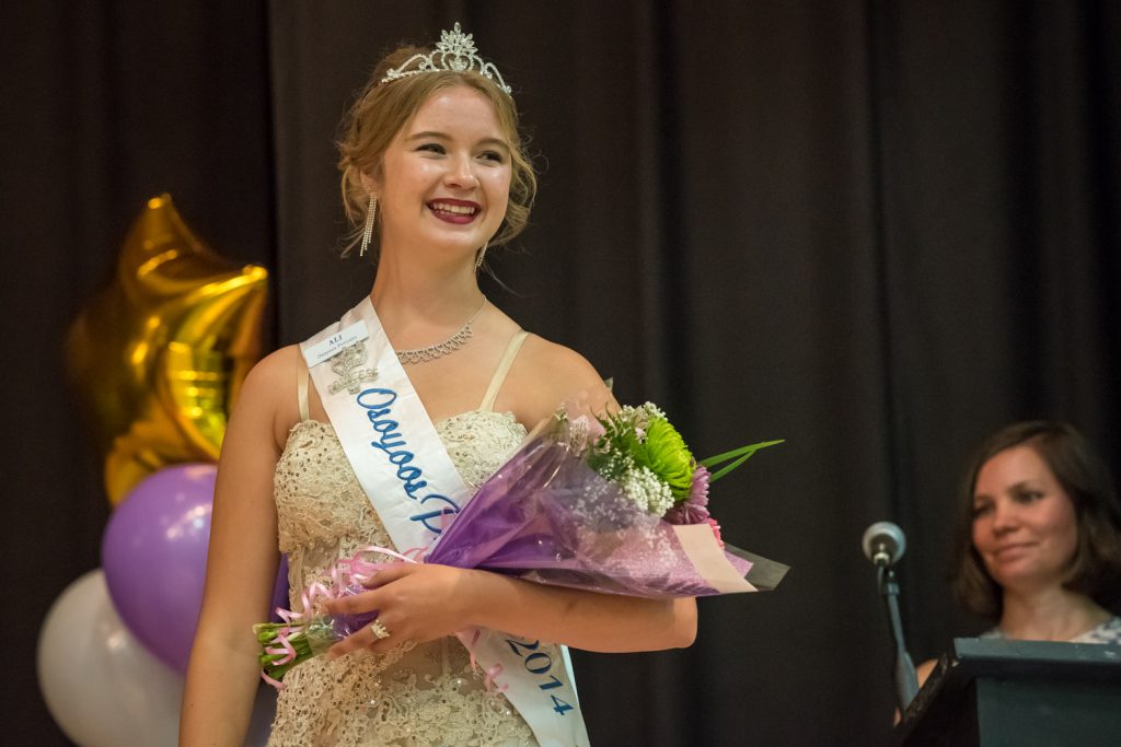 Outgoing Princess Ali Hutter wears her gown and carries flowers while MC Kara Burton looks on. (Richard McGuire photo)