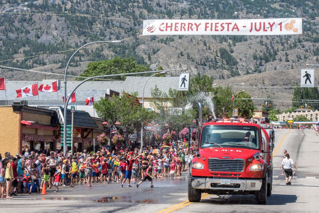 Anarchist Mountain firefighters make their way down Main Street past the attack zone for the water fight, which is in front of Osoyoos Home Hardware. The water fight is a popular highlight of Cherry Fiesta and gets under way just before the parade. (Richard McGuire photo)