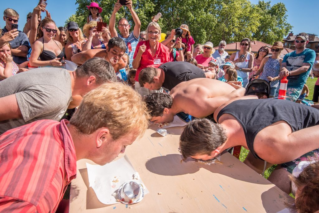 Spectators cheer on the men during the cherry pie eating contest at Cherry Fiesta. Participants raced to eat cherry pies with their hands behind their backs. (Richard McGuire photo)