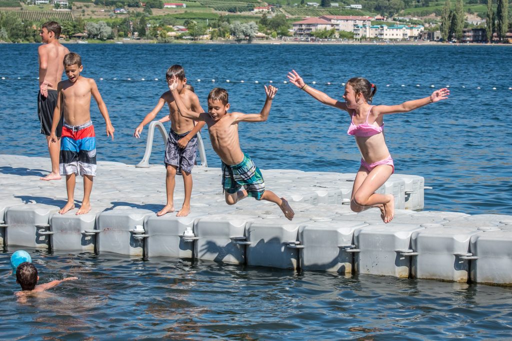 One, two, three, jump. A boy and girl jump into the water from the floating dock at Gyro Beach. (Richard McGuire photo)