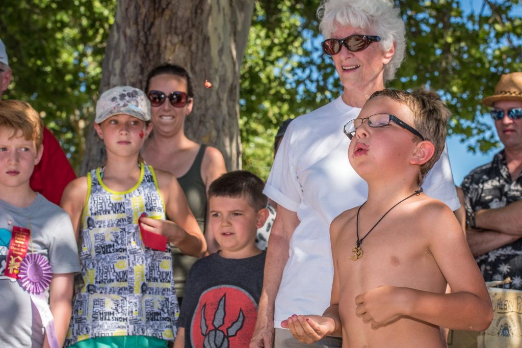 A boy fires off a cherry pit during the pit spitting contest at Cherry Fiesta. (Richard McGuire photo)