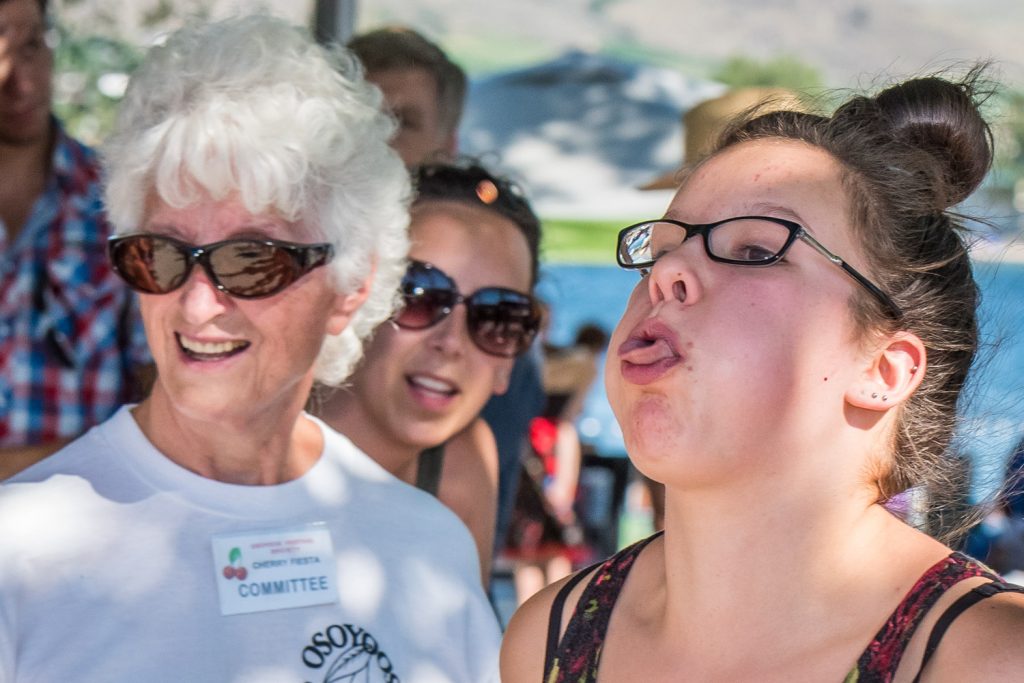 Volunteer Jessie Smythe (left) surveys the trajectory of a cherry pit spat by Vanessa Merk, of Langley. Merk didn't win anything in cherry pit spitting, but she won first place in the cherry pie eating. (Richard McGuire photo)