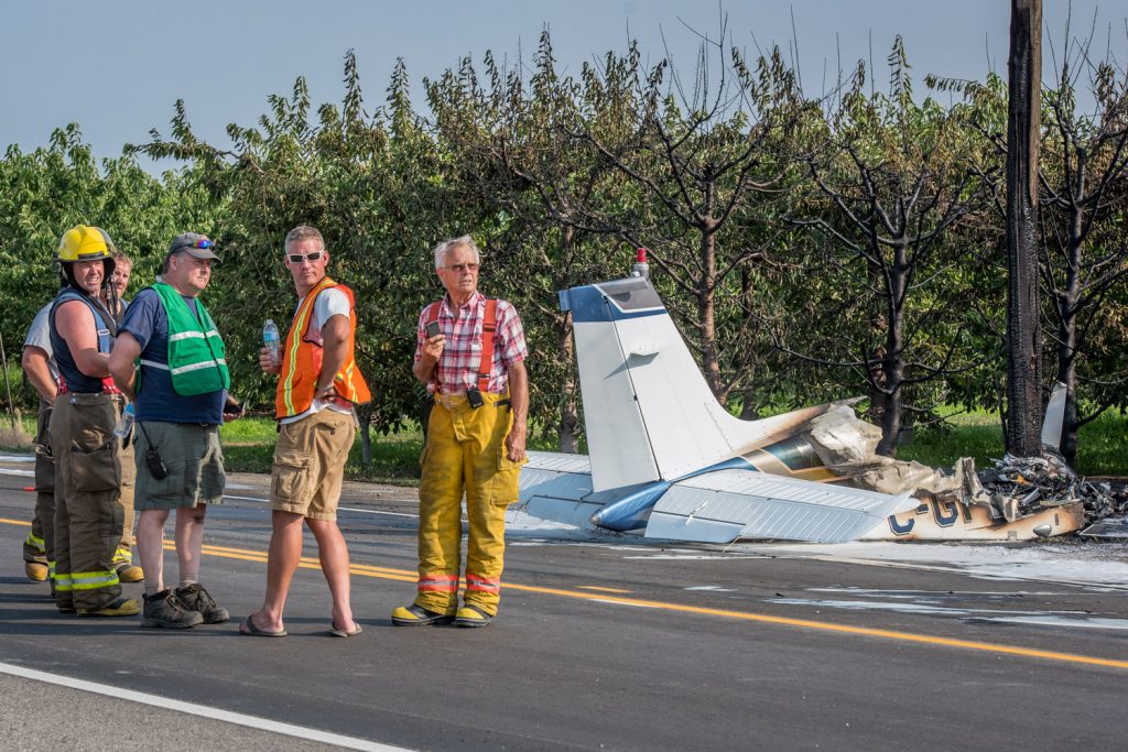 Firefighters survey the scene after they extinguished the fire on a crashed small plane. (Richard McGuire photo)