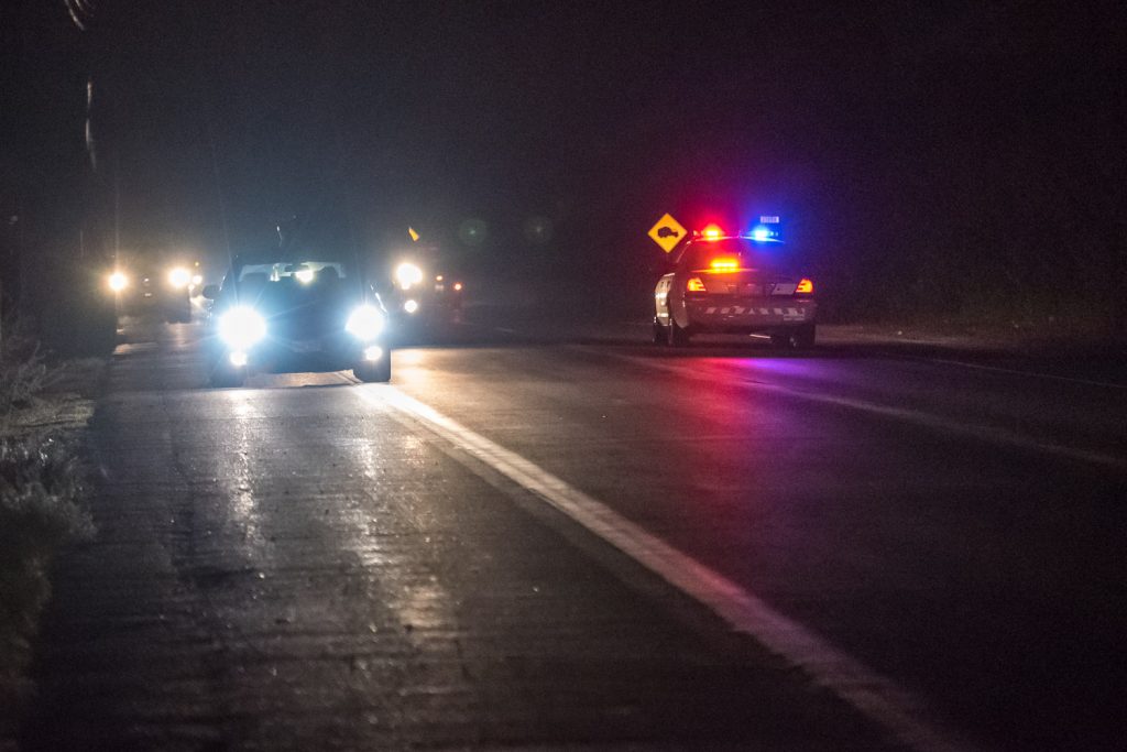 An RCMP car hurries southbound on Highway 97 near the Testalinden fire. Traffic was still getting through on the highway despite very thick smoke. (Richard McGuire photo)