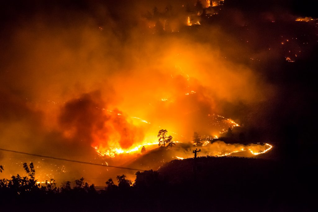 Glowing fire and clouds of smoke create an eerie and terrifying scene a short distance from homes at the base of Testalinden Creek's descent of Mount Kobau. This photo was taken at 9:54 p.m. Friday. (Richard McGuire photo)