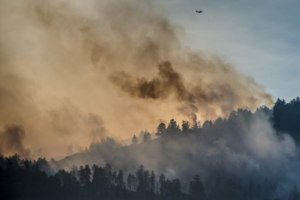 A plane flies over the area above Testalinden Creek as sun strikes the smoke from behind. This photo was taken at 6:15 p.m. Sunday. (Richard McGuire photo)