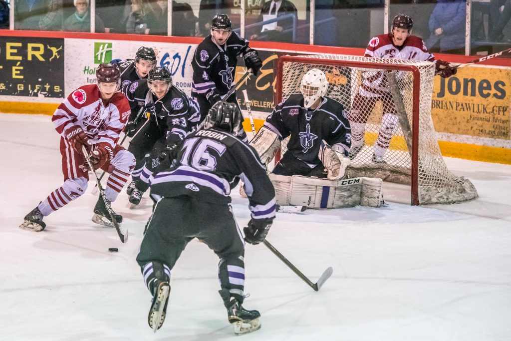It took five North Okanagan Knights to thwart an attack by Coyote Bobby LaRue (left) in last Wednesday's game. Teammate Rainer Glimpel watches as he skates behind the net. The Coyotes eliminated the Knights in four straight games. (Richard McGuire photo)