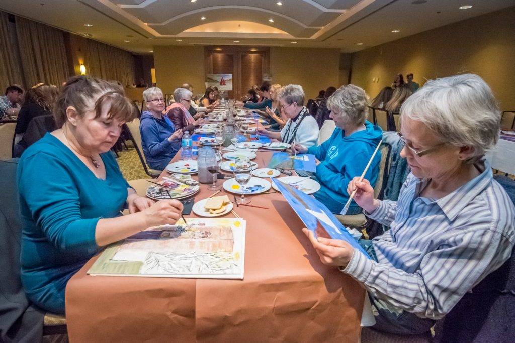 Budding artists turned out Saturday evening at the Watermark Beach Resort for the Osoyoos Lake Water Quality Society's Paint and Sip fundraiser. Guests, many with little or no painting experience, were given a canvas, brushes and acrylic paint and were tasked with creating a painting inspired by Osoyoos Lake. Of course wine, socializing and nibbles were part of the mix. In the foreground are Lorraine Gibson (left) and Trish Murray, both from Osoyoos. (Richard McGuire photo)