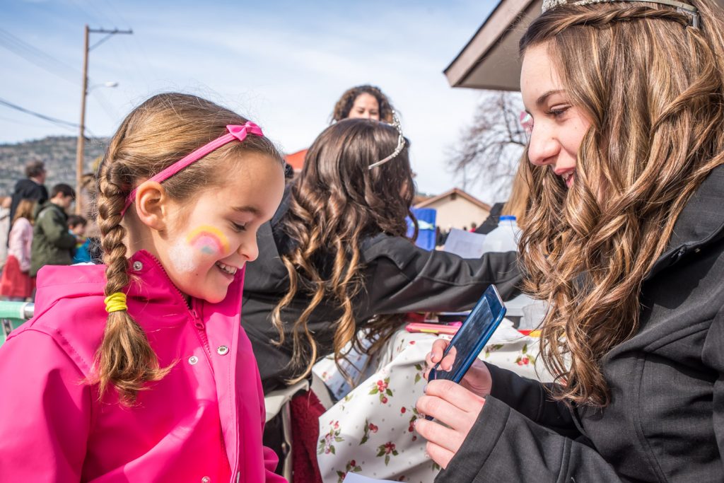 Trinity Gray, 8, of Bridesville, looks at herself in a mirror after Miss Osoyoos, Emma Fernandes painted her face. (Richard McGuire photo)
