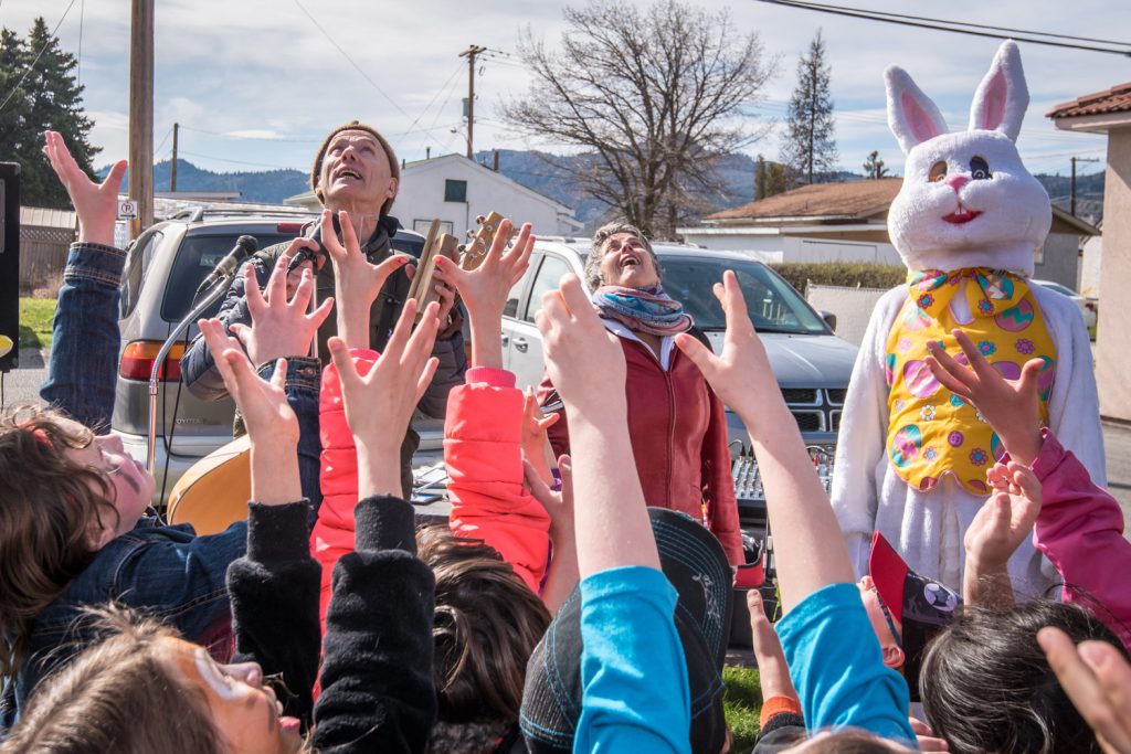 A sea of hands rises into the air to catch a bunny in a bunny toss led by singer Mat Duffus, left. At right, the Easter Bunny, who bore a resemblance to Ken Baker of the Osoyoos Times, wonders if he is next. (Richard McGuire photo)