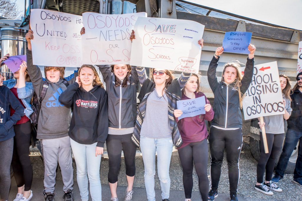 Students wave banners in front of Osoyoos Secondary School to show their support for keeping Osoyoos schools open. Hundreds of local residents turned out to support the students and protest the proposed closures. Many construction trucks were brought in as a backdrop to the protests. (Richard McGuire photo)