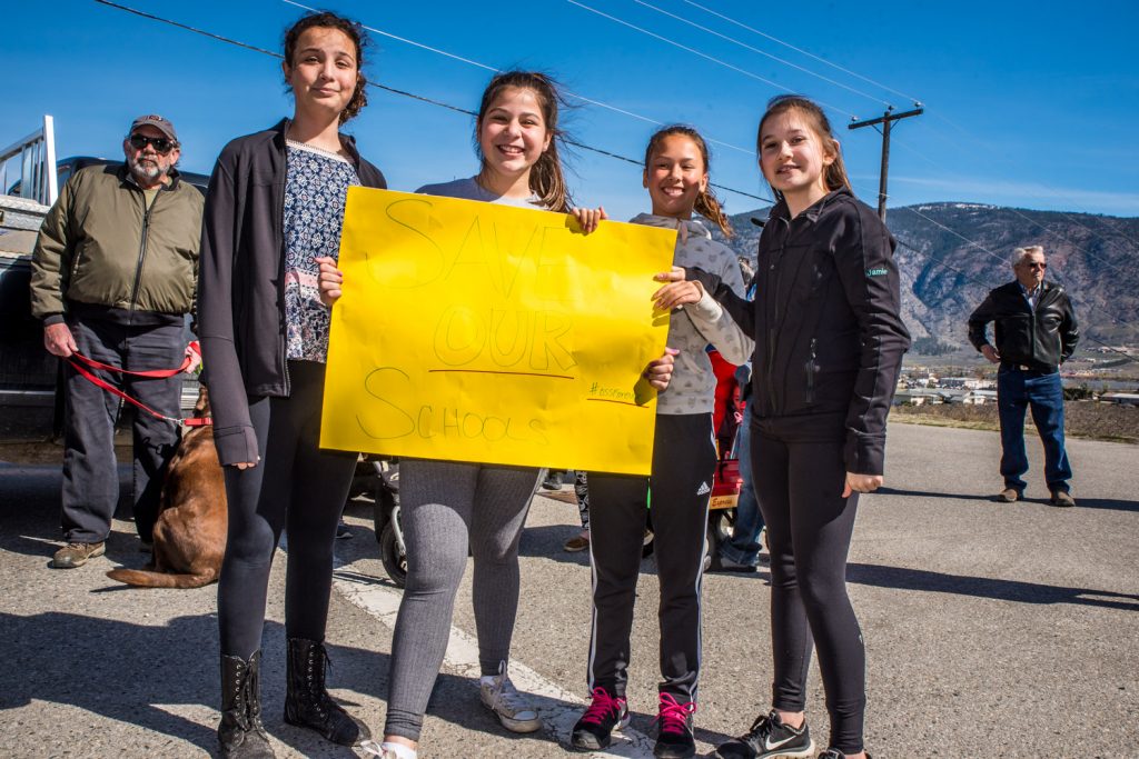 A group of girls holds up a sign with the message "Save Our Schools." (Richard McGuire photo)