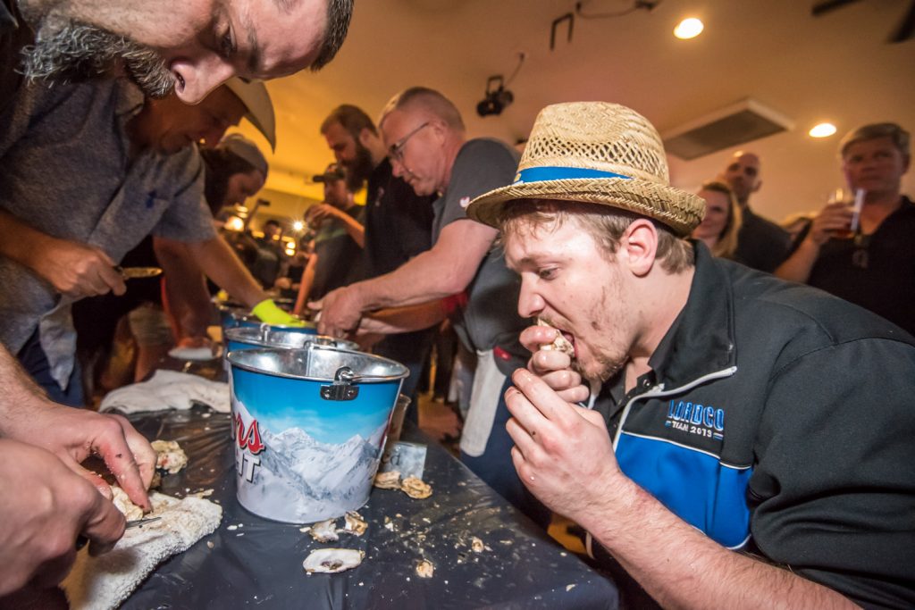 Aaron Zandvliet (right) sucks back oysters to win the Sage Pub's fifth annual Shuck 'n Suck competition. His partner, Andrew Cook, quickly shucks them. The race involves teams of two with one person shucking oysters and the other person sucking them back. Zandvliet and Cook were the defending champions. This was Zandvliet's second year and Cook's third year as a champion. This fun event contrasts with some of the more classy events taking place during the Osoyoos Oyster Festival at resort hotels and wineries. (Richard McGuire photo)