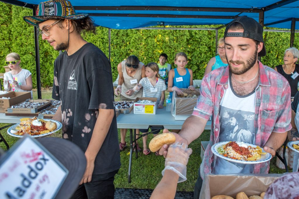 Simon Brousseau-Arcand (left), from Joliette, Quebec, and David Aumont, from Montreal, pick up their Mexican dinner Wednesday evening at Osoyoos Baptist Church. (Richard McGuire photo)