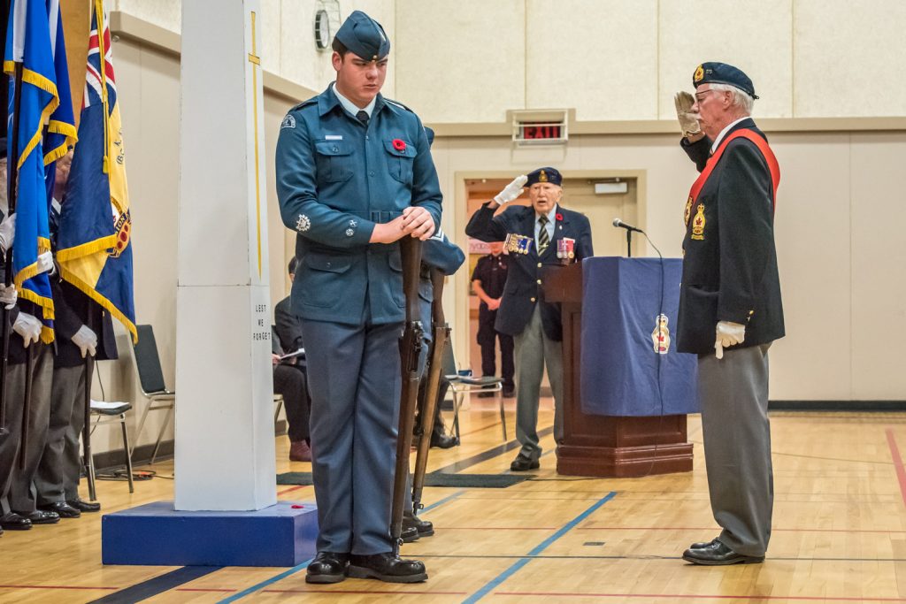 Sergeant-at-Arms Lew Taylor (right) salutes after laying the ceremonial poppy. (Richard McGuire photo)