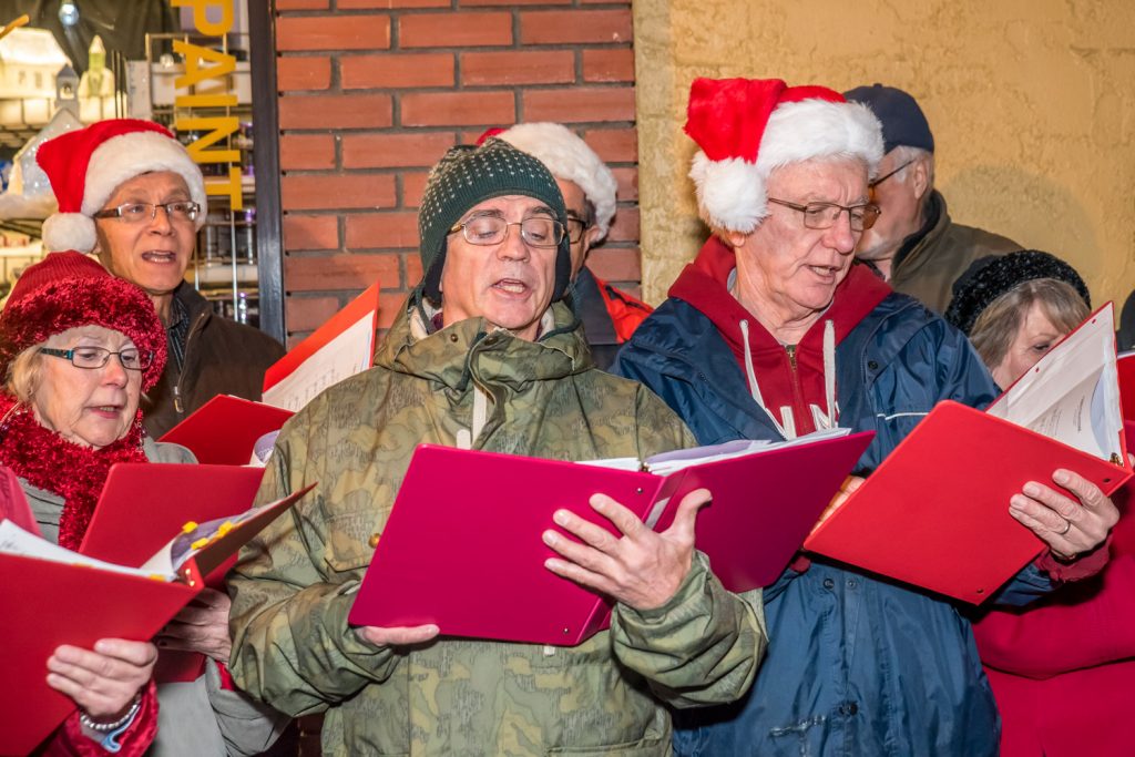 The Okanagan International Chorus, conducted by Lloyd Fairweather, sang Chistmas carols in front of Osoyoos Home Hardware before the parade Friday evening during Christmas Lite-Up. (Richard McGuire photo)