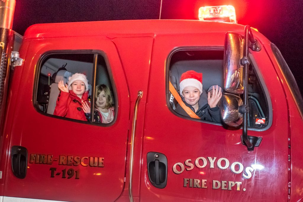 Children wave from the Osoyoos Fire Department truck at the end of the Santa Parade. (Richard McGuire photo)