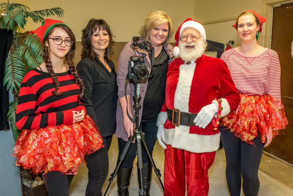 Many children were lined up Saturday morning to get their photos taken with Santa Claus at the Osoyoos Baptist Church. The event was sponsored by Osoyoos Child Care Centre. Pictured is the team behind the photos. From left are Shy-Anne Piche, Kirsten McLean, Nikki Young of Nikki Dawn Photography, Santa, and Sara Smiley. Piche and Smiley, the two elf helpers, were promoting the Osoyoos Secondary School Dram Club's upcoming production of Beauty and the Beast. (Richard McGuire photo)