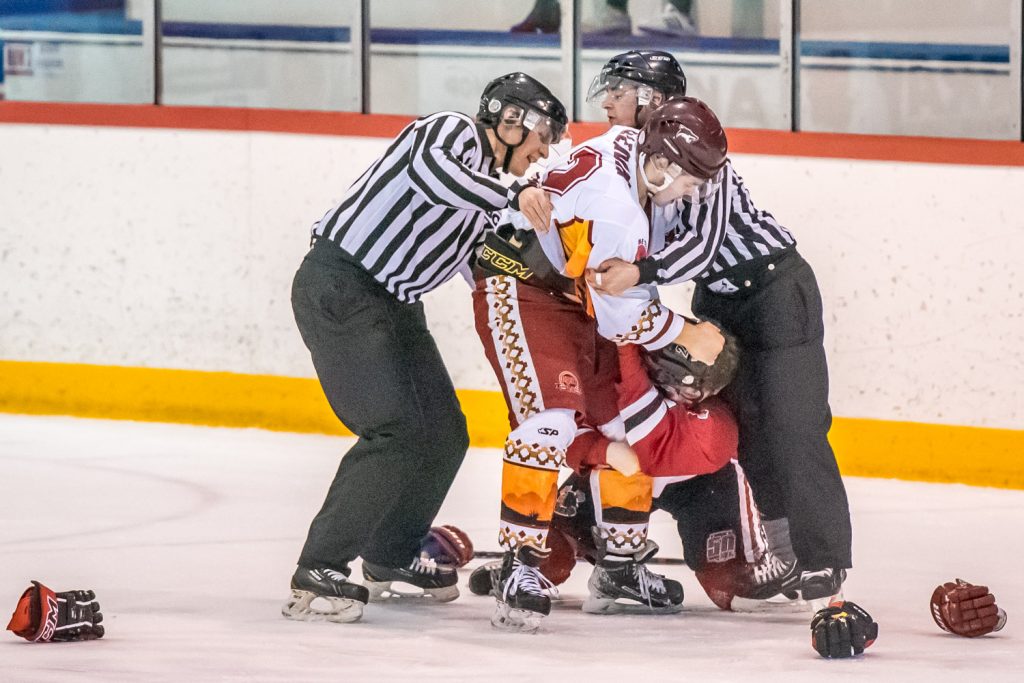 Linesmen Riley Kouwenhoven and Matthew Frizzy try to pull apart Austin Cleaver of the Coyotes and Landon Gran of the Chiefs as they go at each other in the second period. Both got major fighting penalties and game misconducts. (Richard McGuire photo)