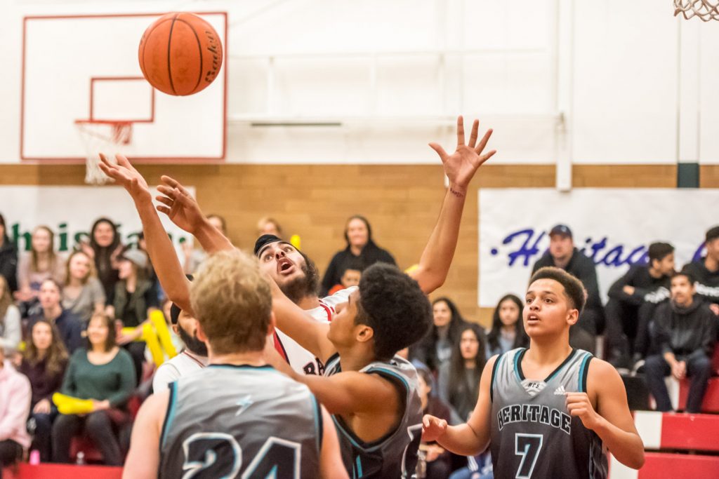 Surrounded by players from Heritage Christian School, Gurlal Dhaliwal of the Rattlers tries to grab the ball. (Richard McGuire photo)