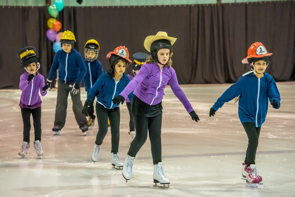 Youngsters in the Canskate Green group wear appropriate hats over their helmets for a skate to the song YMCA. (Richard McGuire photo)