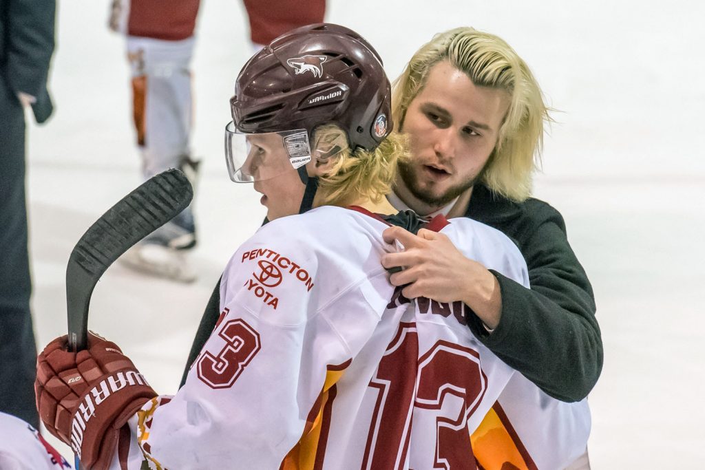 Osoyoos hometown boy Evan Paolera, off with a broken shoulder, comforts Sam Reinbolt after the Coyotes were eliminated in a 3-1 fifth game. (Richard McGuire photo)