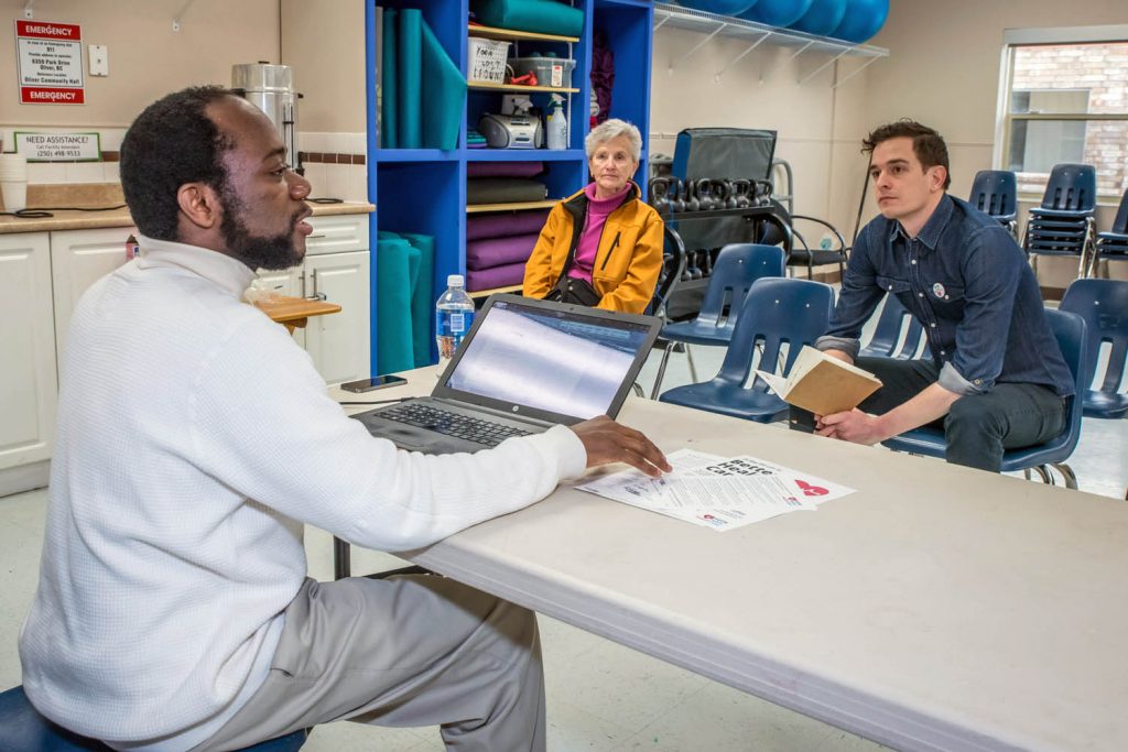 Ismael Traore, the organizer for BC Health Coalition in the Okanagan, led a discussion of health issues on Saturday at the Oliver Community Centre. Attendance was low as the event wasn't well publicized, but those attending had a lively discussion. Listening are Oliver resident Dawn Landau and Vancouver-based organizer Adam Friesen. (Richard McGuire photo)