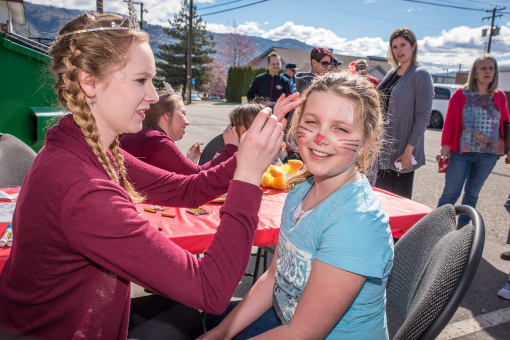 Laura Devries, Osoyoos Princess, paints the face of Samantha McDonald, 10, from Calgary. The Osoyoos Royalty, which is becoming the Osoyoos Ambassadors, have traditionally helped out with games and children's activities at Easter Eggstravaganza. (Richard McGuire photo)