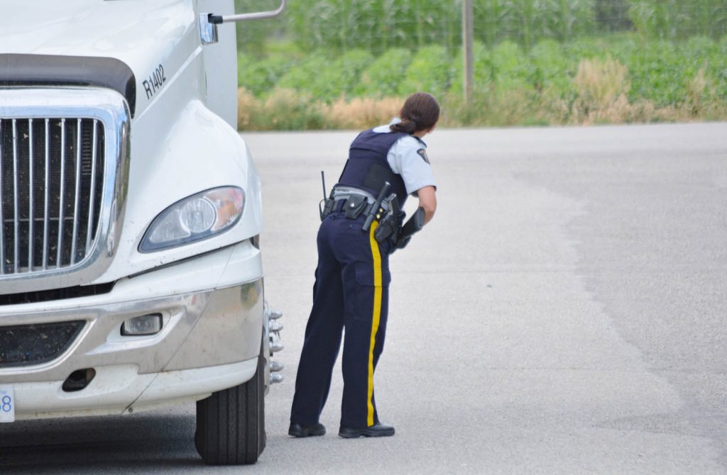 A police officer keeps careful watch during the manhunt for prolific offender Ronald Teneycke last July. Teneycke entered guilty pleas on four charges last week. Now the shooting victim, Wayne Belleville, has spoken about his ordeal with the criminal and his close brush with death, when he was shot and left for dead. (Lyonel Doherty photo)