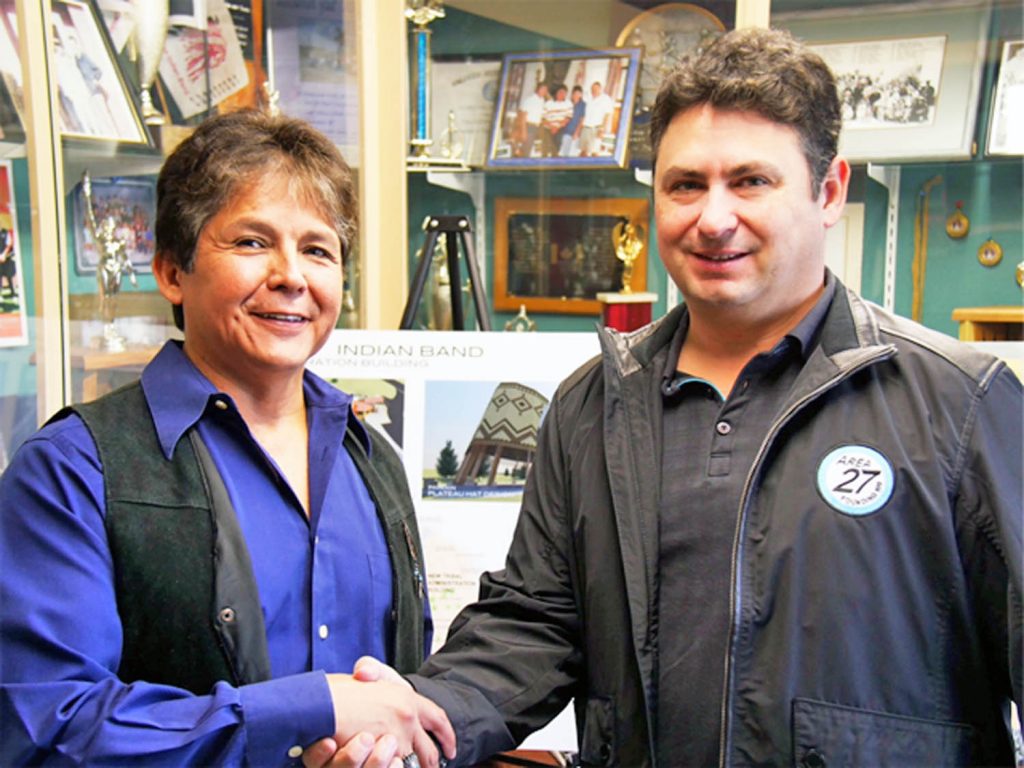 Osoyoos Indian Band Chief Clarence Louie and Bill Drossos, the co-founder and president of the Area 27 racetrack facility, shake hands after signing a 99-year lease agreement last week. Construction on the facility is underway this week. (Photo supplied)
