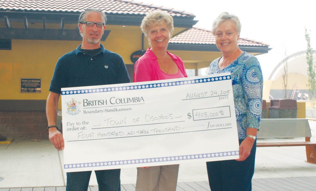 Linda Larson (centre), the MLA for Boundary-Similkameen was in Osoyoos on Monday morning to hand out a cheque for $403,000 to Osoyoos Mayor Sue McKortoff. Also on hand was Osoyoos councillor Mike Campol. The money from the provincial government is the latest instalment in Resort Municipality Initiative (RMI) funding handed out to 14 resort municipalities across B.C. The money will be used to promote tourism and improve tourism-related infrastructure. (Keith Lacey photo)