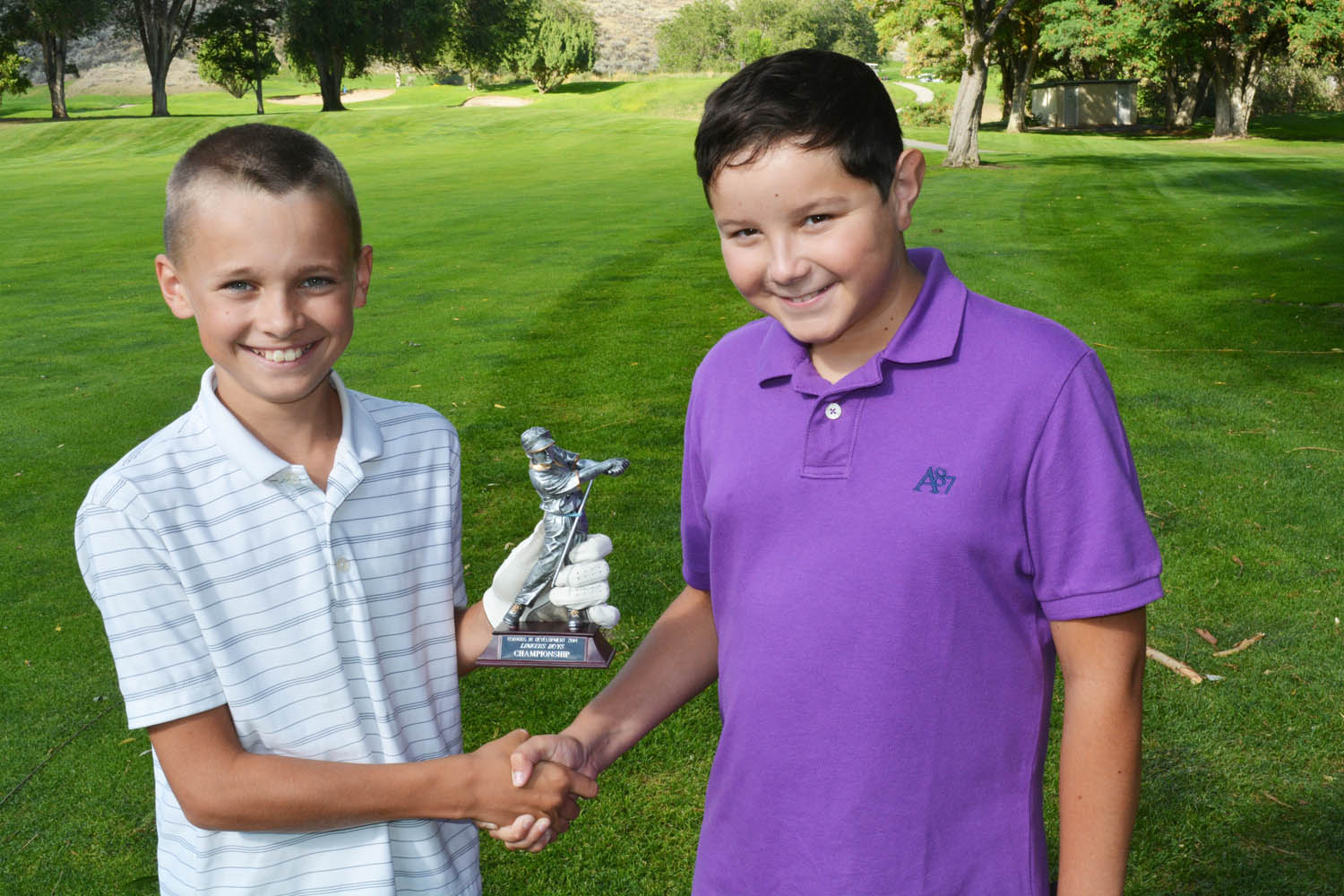 The Osoyoos Junior Golf Development Program wrapped up a successful 2014 season this past weekend with a junior tournament on Saturday and junior-adult event on Sunday, which was followed by an awards presentation and dinner. Aidan Nelmes (left) from Osoyoos holds his championship trophy with runner-up Roanin Law in the boys 11-13 age division. (Lyonel Doherty photo)