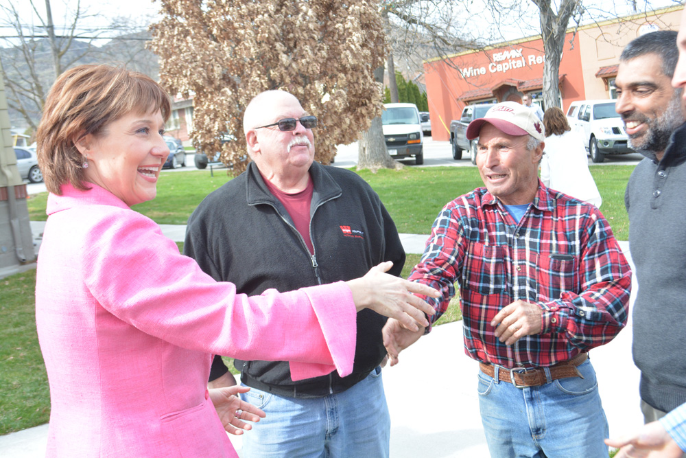 BC Premier Christy Clark shakes hands with local farmers during her visit to Oliver on Monday to provide emergency funding to the town for irrigation canal repair. In middle is water councillor Andre Miller, standing beside fruit grower Joe Machial and Pinder Dhaliwal, vice-president of the BC Fruit Growers' Association. (Lyonel Doherty photo)