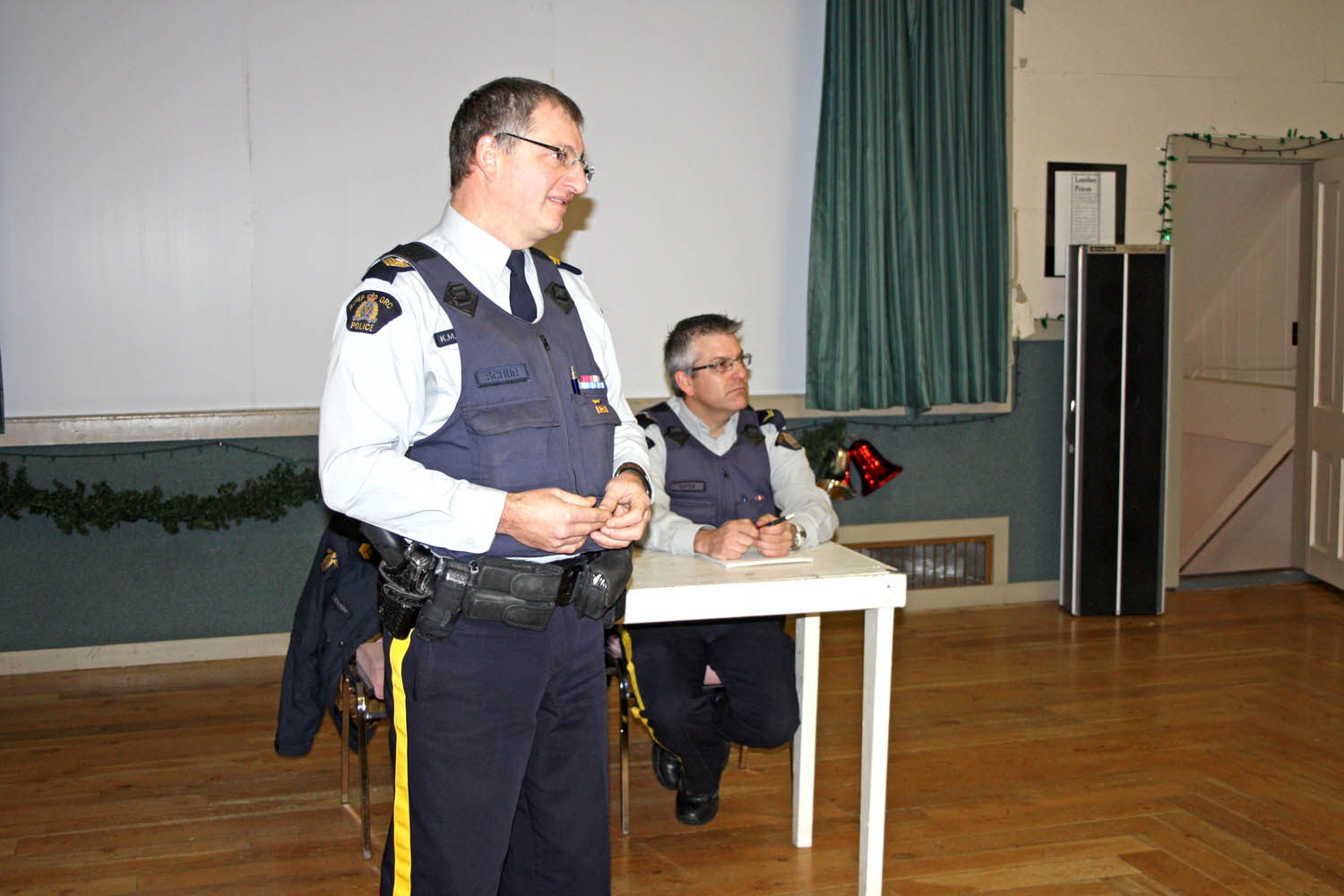 RCMP Sgt. Kevin Schur (left) addressed residents of Bridesville accompanied by Cpl. Jason Bayda. RCMP organized a town hall meeting to discuss the high volume of calls to police, but many residents wanted to talk about their problems with one local individual. (Keith Lacey photo)