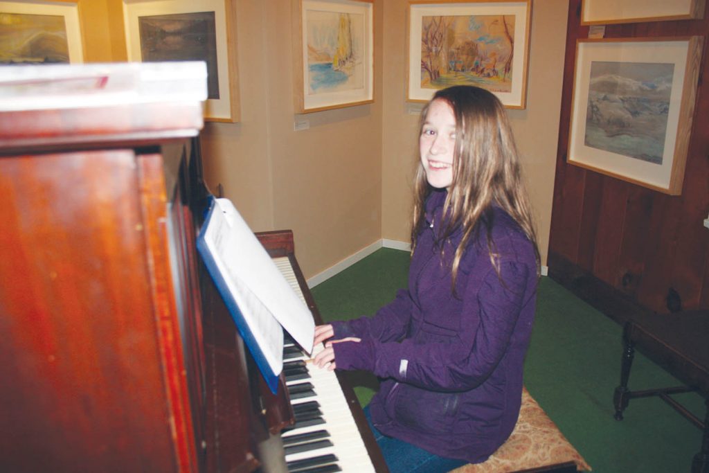 Kaelyn Burton, 12, shows off her excellent musicianship on the old piano that is part of the exhibits inside the museum. (Keith Lacey photo)
