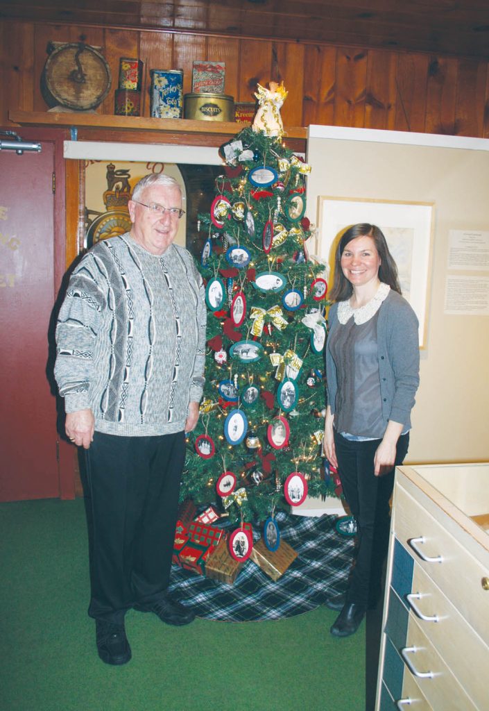 The Osoyoos Museum held its annual Christmas open house event this past Saturday and dozens of local residents and snowbirds took the time to take a brief tour and enjoy some coffee, tea and snacks. In order to attract new visitors, the museum has been sponsoring an open house event almost once a month over the past year. Above, Osoyoos Museum board chair Mat Hassen stands in front of a decorative Christmas tree with museum manager Kara Burton. The tree was decorated with photos of local residents taken from the archives. (Keith Lacey photo)
