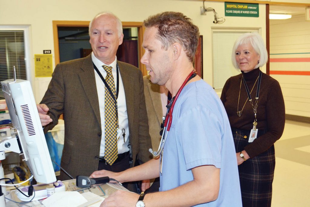 Licensed Practical Nurse Jaret Blidook shows Interior Health CEO Chris Mazurkewich the hospital’s innovative computer system while acute care administrator Lori Motluk looks on. Mazurkewich toured the facility and got a first-hand look at why the hospital is envied for its innovative computer system. (Lyonel Doherty photo)