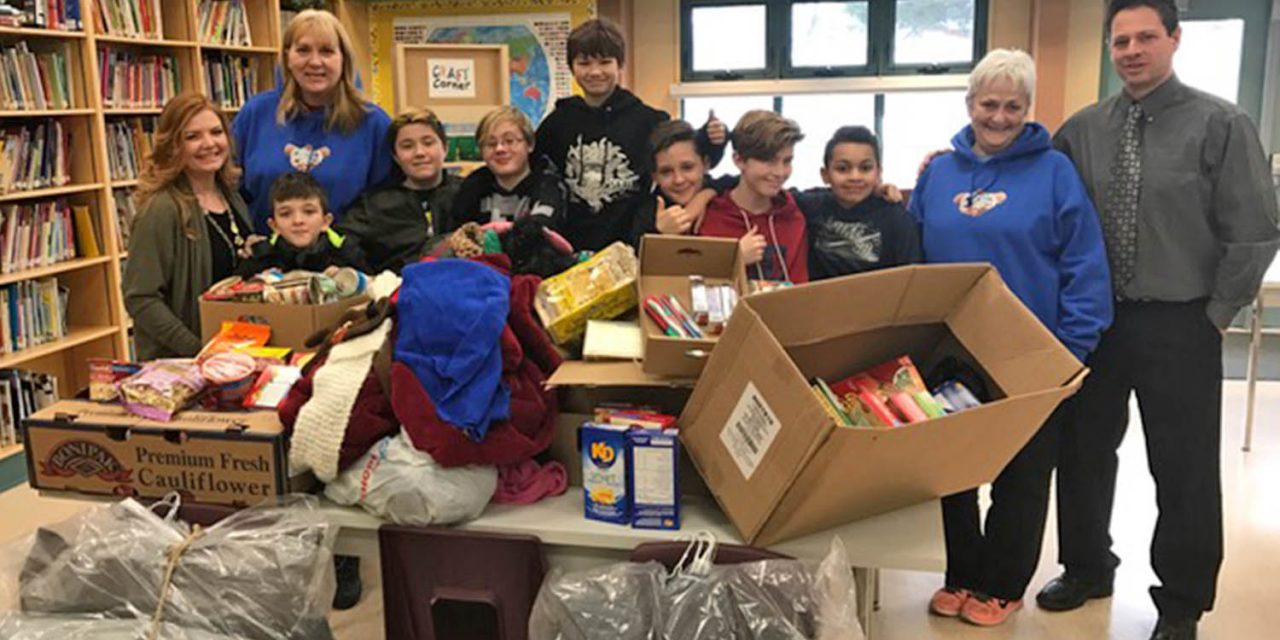 Group of young male students gather food and clothing to benefit community
