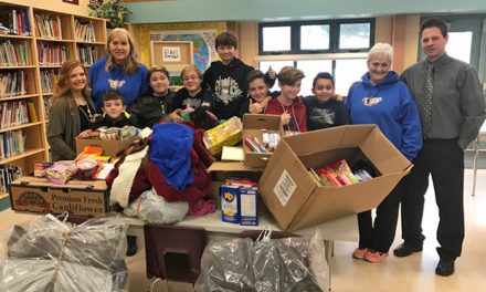 Group of young male students gather food and clothing to benefit community