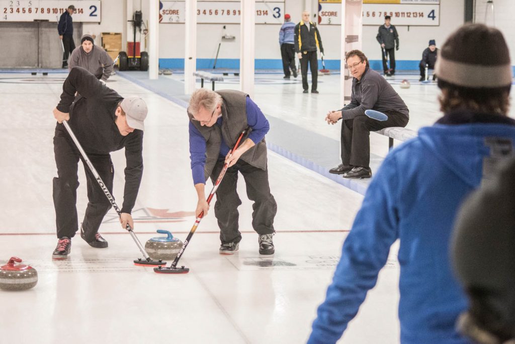 Dean Vincent and Dan Scott sweep feverishly to guide a rock thrown by Rob Tinsley into the rings. A total of 26 teams from across the province, including 10 local teams, competed. (Dan Walton photo)