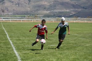 Photo by Keith Lacey An Osoyoos player (red shirt) controls the ball while an Oliver player challenges him in a U-15 playoff game Saturday. The league is holding a huge tournament in Osoyoos.