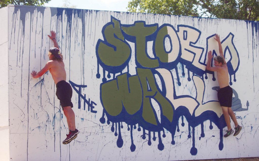 Two competitors taking part in the competitive relay race at the Storm the Wall event held last Thursday at Osoyoos Secondary School strain to try and reach for the top of the 10-foot wall. The Storm the Wall event was combined with an outdoor track meet as the entire student body took part in a full day of competition and good times. (Keith Lacey photo)