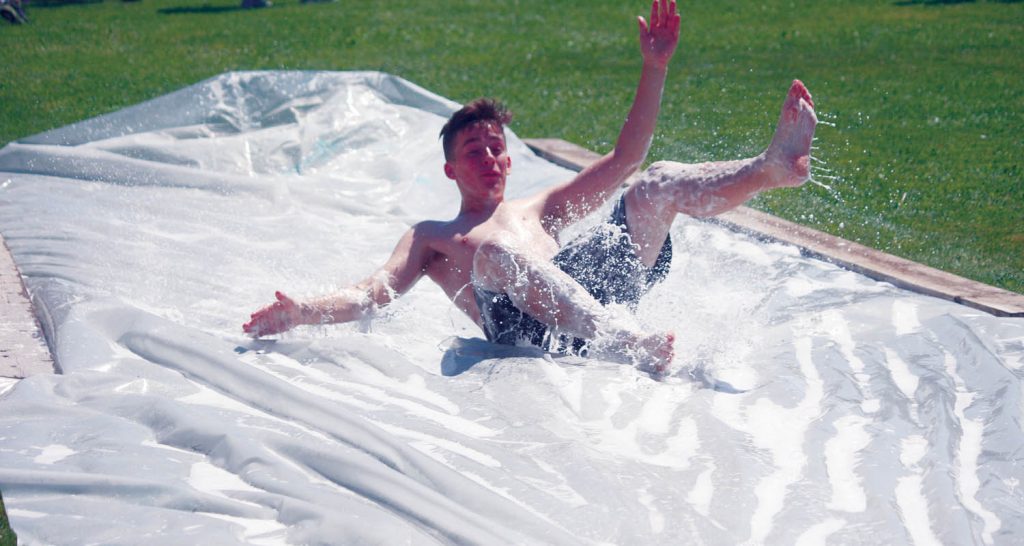 A young student is all smiles as he wipes out after hitting the water slide. (Keith Lacey photo)