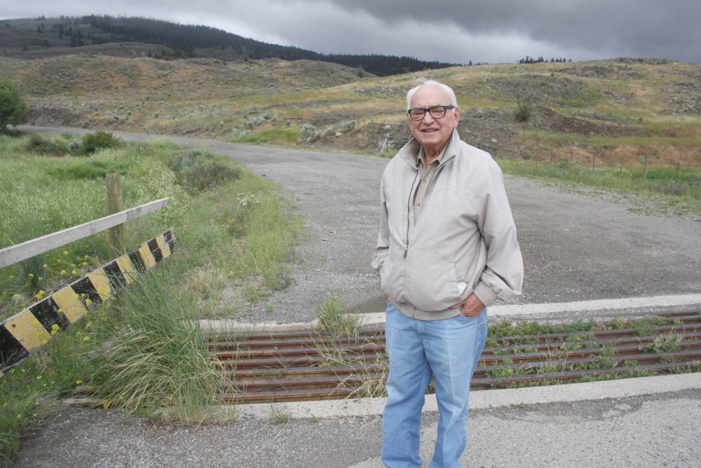 Walter Cook, the engineer in charge of building a road 50 years ago that would have led to Canada’s largest astronomical observatory on Mount Kobau, is still upset that the project was cancelled. Pictured here, he stands at the base of the road up the mountain. Despite the disappointment, he and his wife Virginia ended up staying in Osoyoos. (Keith Lacey photo)